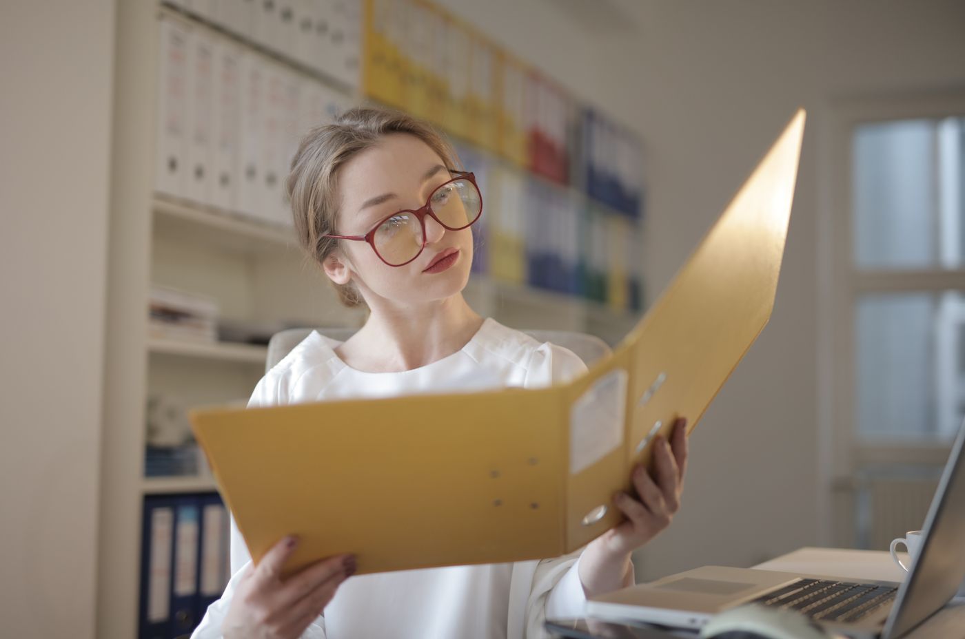 Une professionnelle examine les pièces d’un dossier comptable.